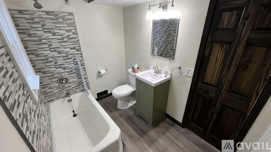 A bathroom with a stone wall and a white bathtub.