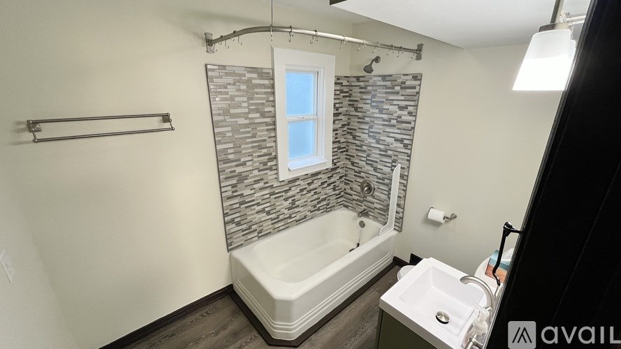 A bathroom with a stone wall and a white bathtub.
