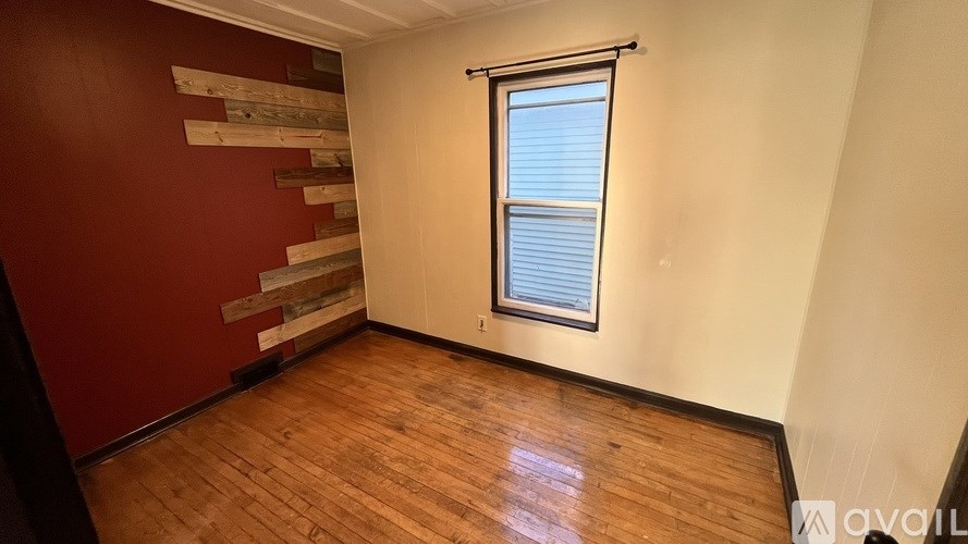 A room with wooden floors and a staircase with wooden planks.
