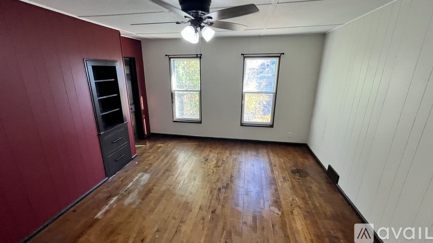 A room with wooden floors and a ceiling fan.