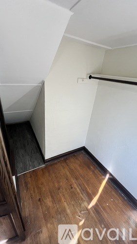 A room with a wooden floor and a white wall.