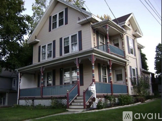 A two-story house with a balcony and stairs leading to the front door.