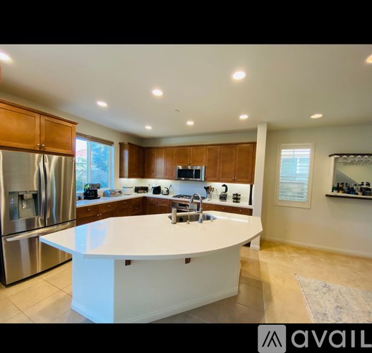 A modern kitchen with a center island and stainless steel appliances.