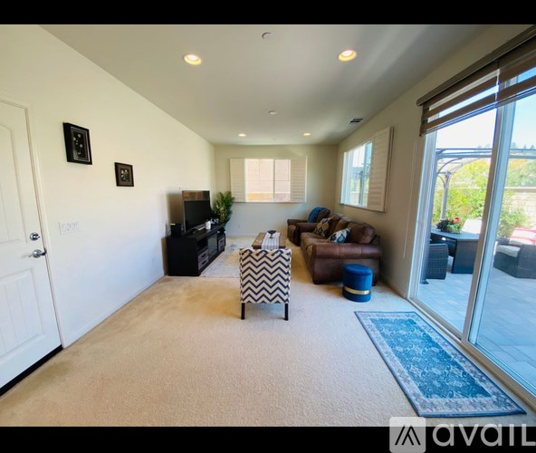 A living room with a sofa, a chair, and a television.