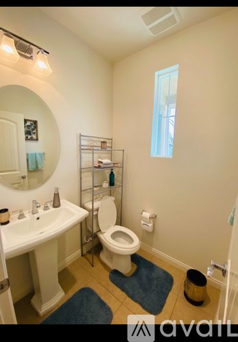 A bathroom with a toilet, sink, and mirror.