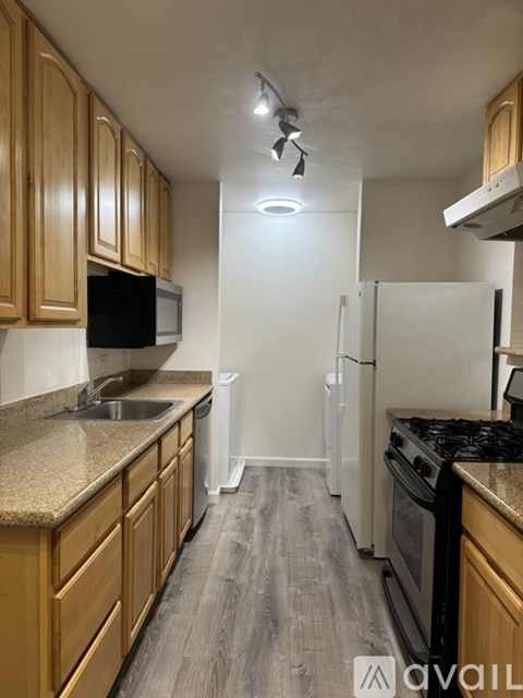 A kitchen with wooden cabinets and a black countertop.