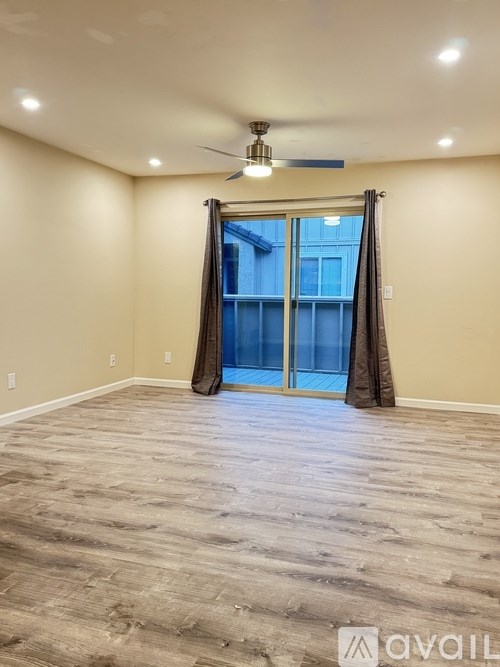 A room with a sliding glass door and a ceiling fan.