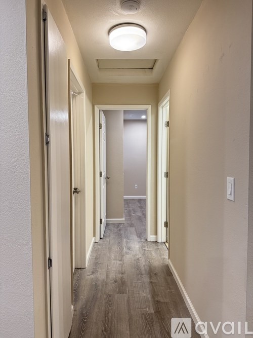 A long hallway with doors on both sides and a light on the ceiling.