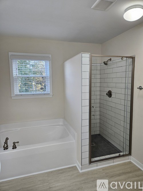 A bathroom with a white tub and a walk-in shower.