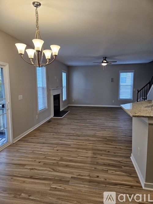 A living room with a chandelier and a ceiling fan.