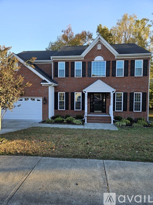 A red brick house with a white garage door and a covered front porch.