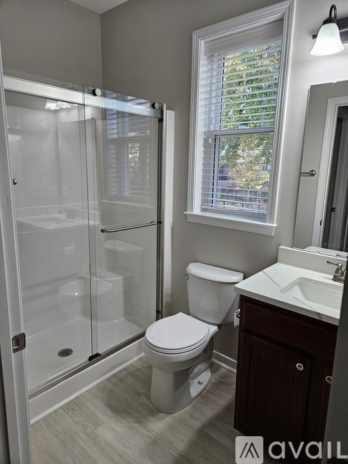A bathroom with a toilet, sink, and shower.