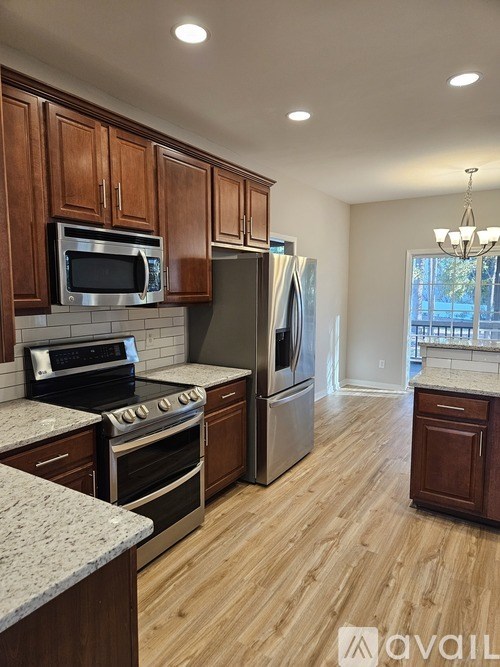 A kitchen with wooden cabinets and a granite countertop.