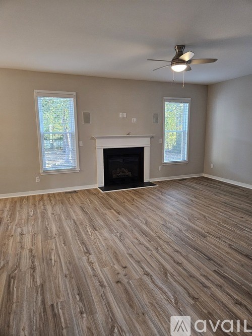 A room with a fireplace and wood flooring.
