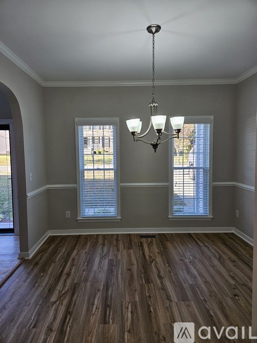 A room with wooden floors and a chandelier.