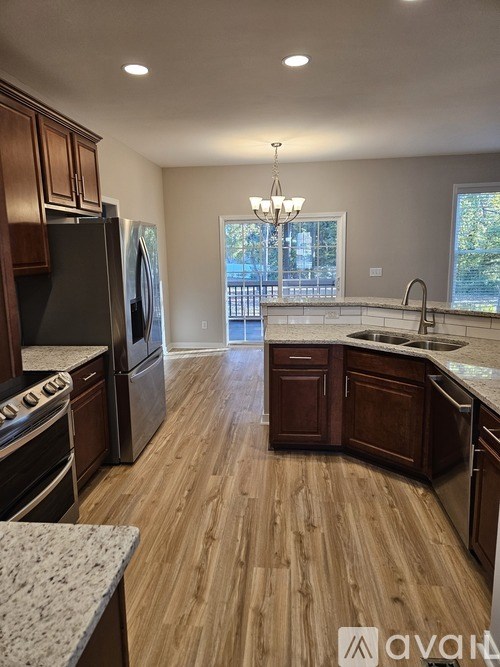 A kitchen with wooden cabinets and a black refrigerator.