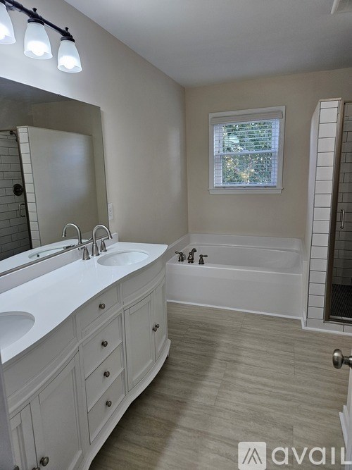 A bathroom with a white sink and a white bathtub.