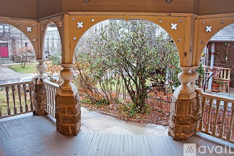 A balcony with a view of a tree and a building.