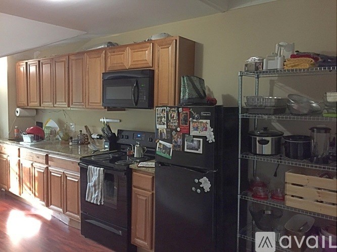A kitchen with black appliances and wooden cabinets.