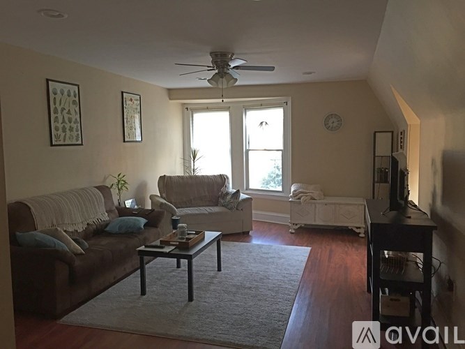 A living room with a brown couch, a white chair, and a coffee table.