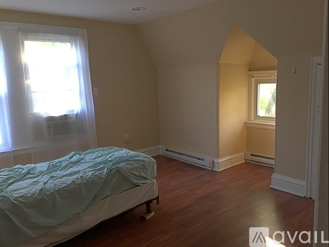 A bedroom with a bed and a window.