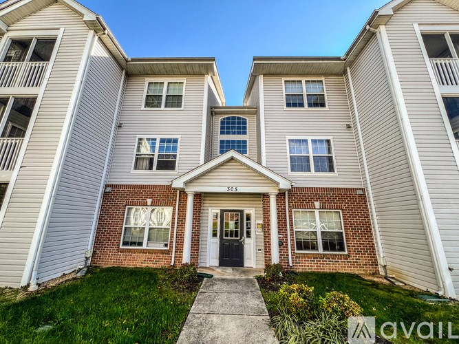 A two-story house with a front porch and a black door.