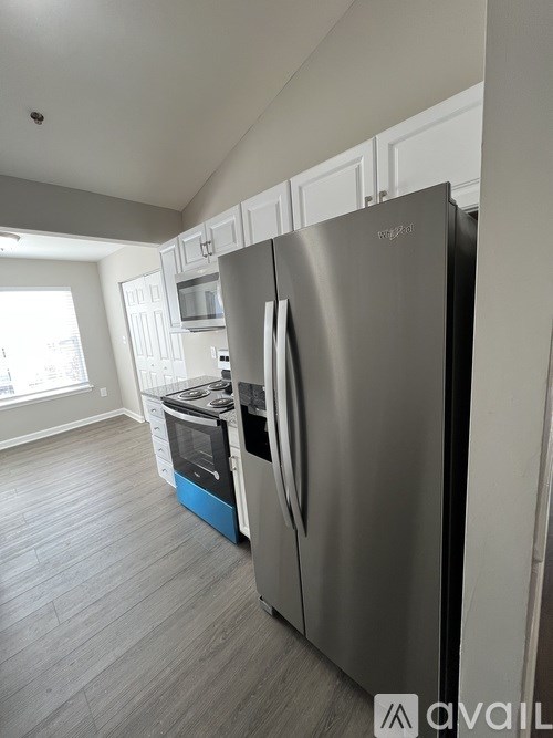 A stainless steel refrigerator with a blue bottom sits in a kitchen.