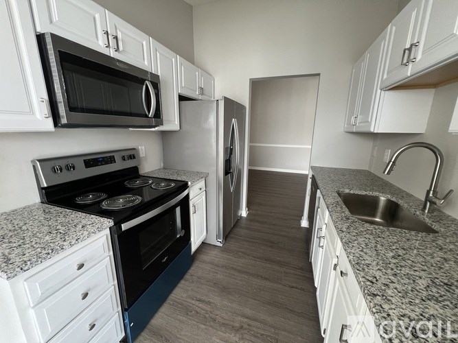 A kitchen with white cabinets and a black stove top oven.