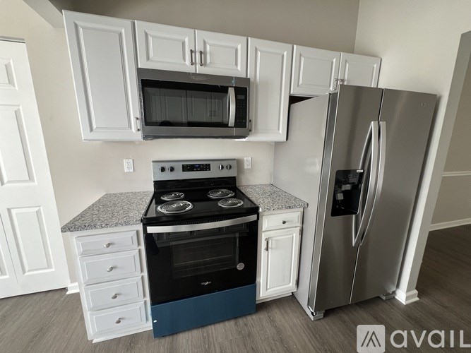 A kitchen with white cabinets and a black stove top oven.