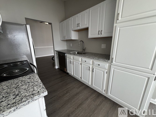 A kitchen with white cabinets and a granite countertop.