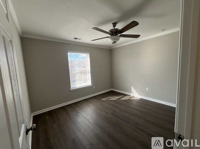 A room with a ceiling fan and a window with blinds.