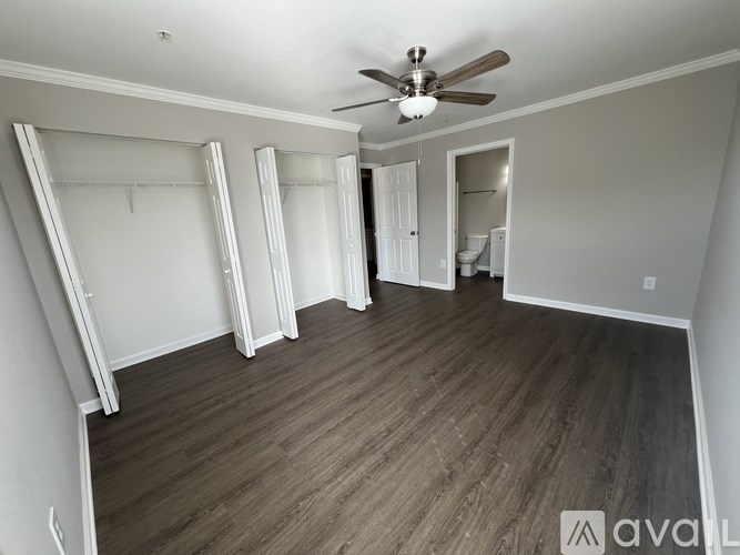 A room with a ceiling fan and wooden flooring.