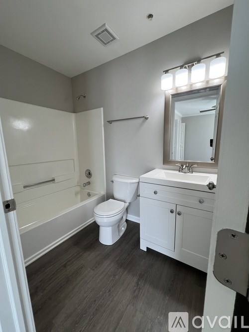 A bathroom with a white toilet, sink, and bathtub.