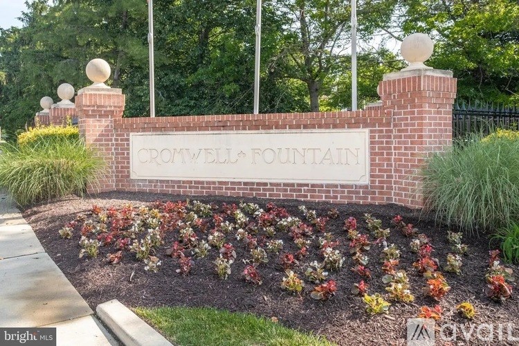 A sign that says "Cromwell Fountain" is surrounded by flowers.