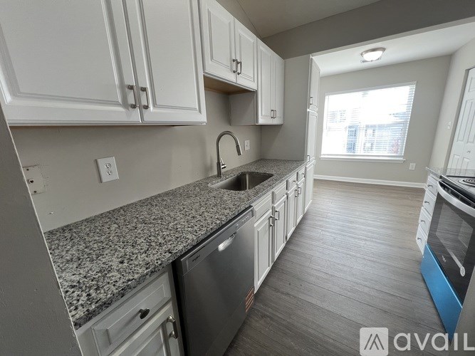 A kitchen with granite countertops and white cabinets.