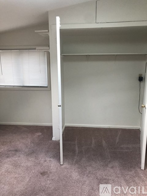 A room with a bunk bed and a window with blinds.