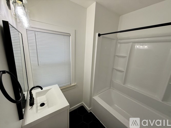 A white sink is on the counter next to a window in a small bathroom.