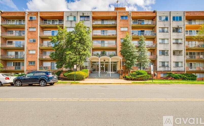 A large apartment building with a car parked in front.