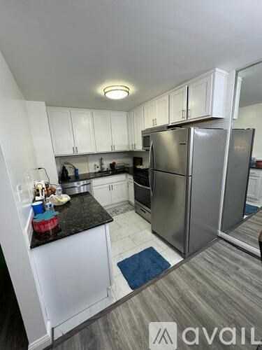 A kitchen with a black countertop and stainless steel appliances.