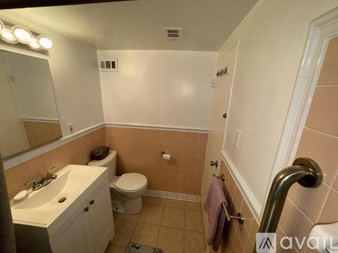 A bathroom with a toilet, sink, and shower.