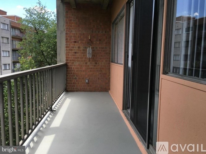 A balcony with a black railing and a brick wall.