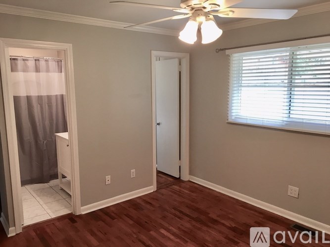 A room with a ceiling fan and a window with blinds.