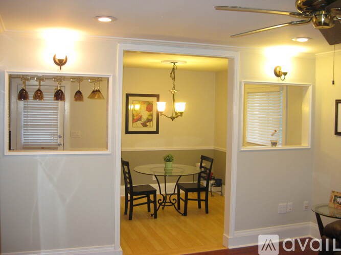 A dining room with a glass table and chairs.