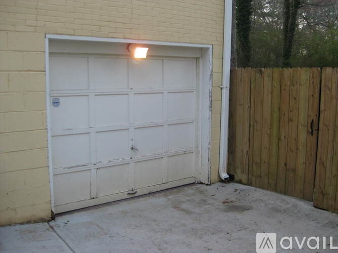 A white garage door is closed and has a light on it.