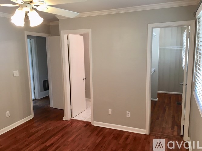 A room with a ceiling fan and wooden floors.