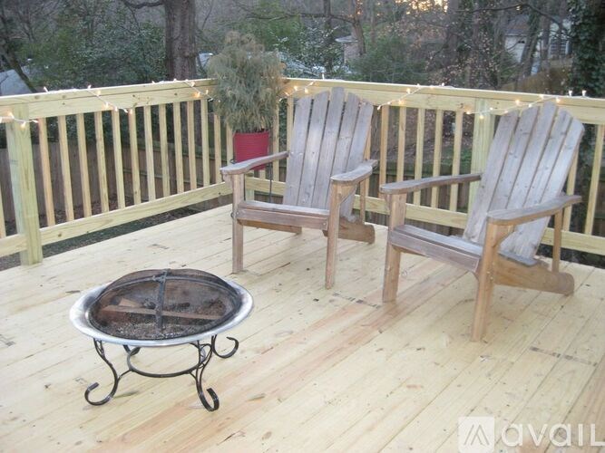 A wooden deck with two chairs and a table.