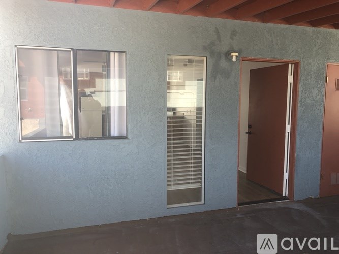 A room with a brown door and a window with blinds.