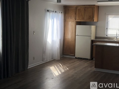 A kitchen with wooden cabinets and a white refrigerator.