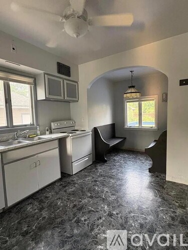 A kitchen with granite countertops and a window seat.