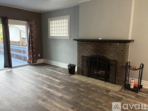 A living room with a fireplace and a window.